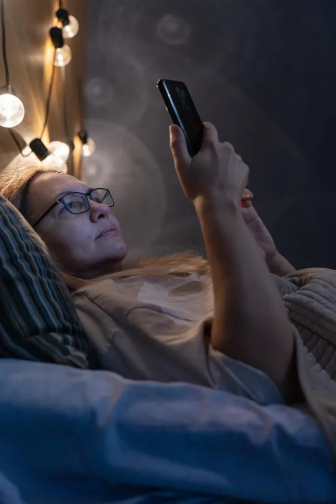 Personne utilisant son smartphone la nuit, difficulté à se détacher des écrans