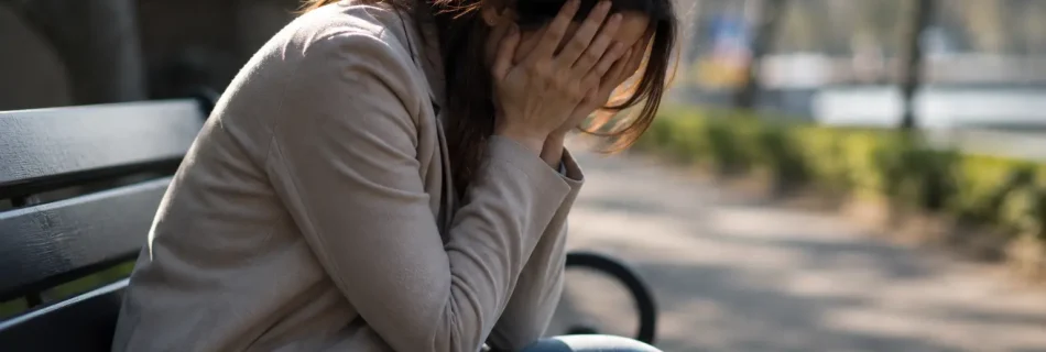 femme stressée assise sur un banc tête dans les mains pensées envahissantes fatigue mentale